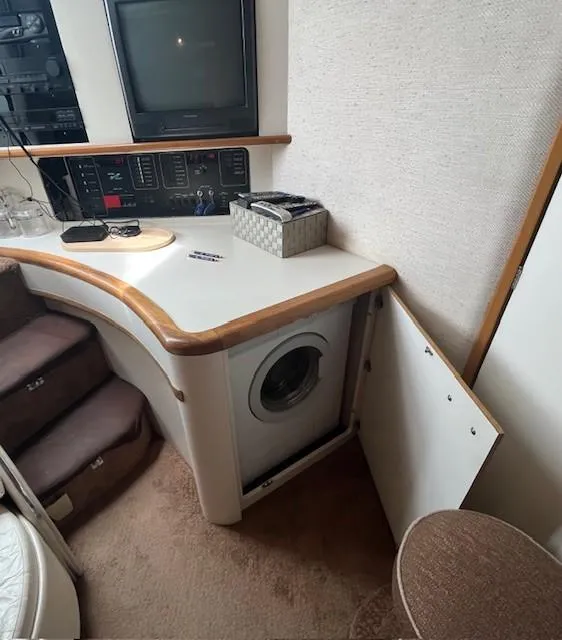 Slide: The Image of 1992 Sea Ray Sundancer interior with washer, TV, and control panel. - 19