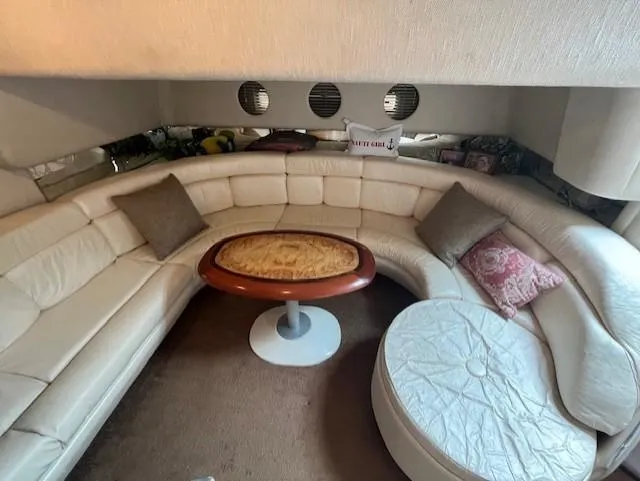 Slide: The Image of 1992 Sea Ray Sundancer interior with curved white leather seating and wooden table. - 20