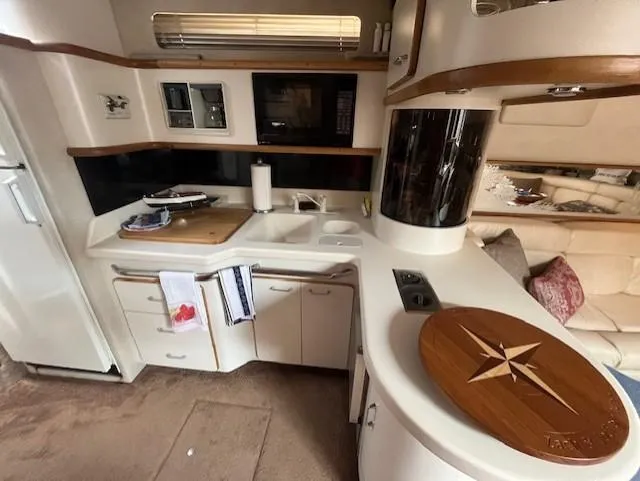 Slide: The Image of 1992 Sea Ray Sundancer kitchen area with modern appliances and wooden accents. - 21