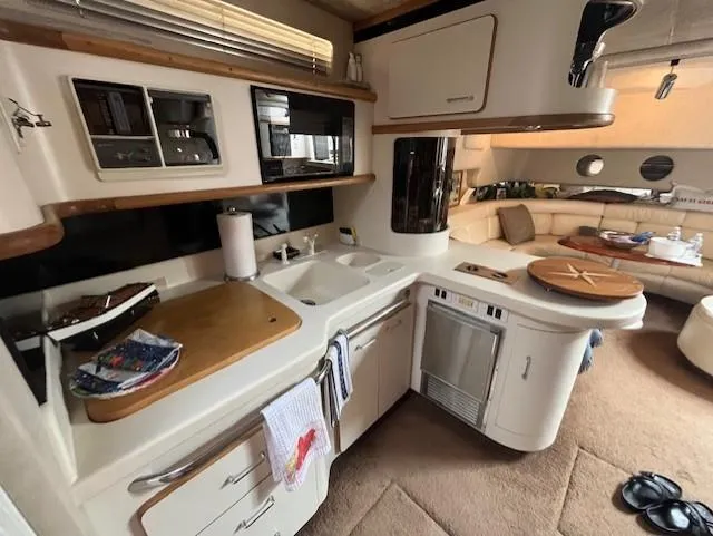 Slide: The Image of 1992 Sea Ray Sundancer yacht interior kitchen with modern amenities and cozy seating area. - 22