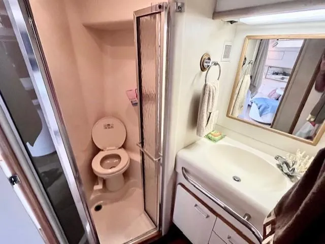 Slide: The Image of 1992 Sea Ray Sundancer bathroom with shower, toilet, sink, and mirror. - 27