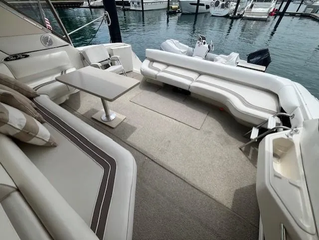Slide: The Image of 1992 Sea Ray Sundancer boat interior with seating and table, docked at marina. - 3