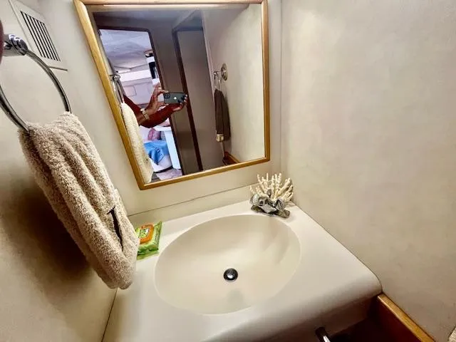 Slide: The Image of 1992 Sea Ray Sundancer bathroom with sink, mirror, towel, and soap. - 33
