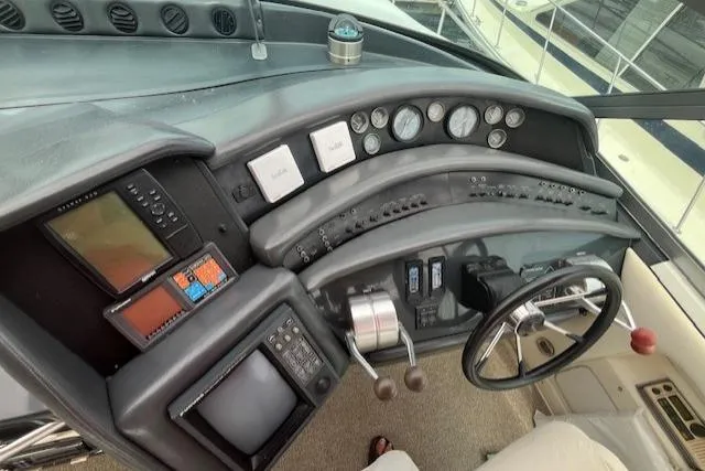 Slide: The Image of 1992 Sea Ray Sundancer boat dashboard with navigation instruments and steering wheel. - 9