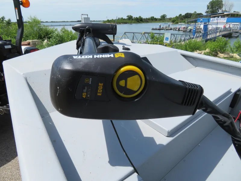 Slide: The Image of Minn Kota Edge trolling motor on 2023 G3 Sportsman 1610 SS boat, docked by a lake. - 2