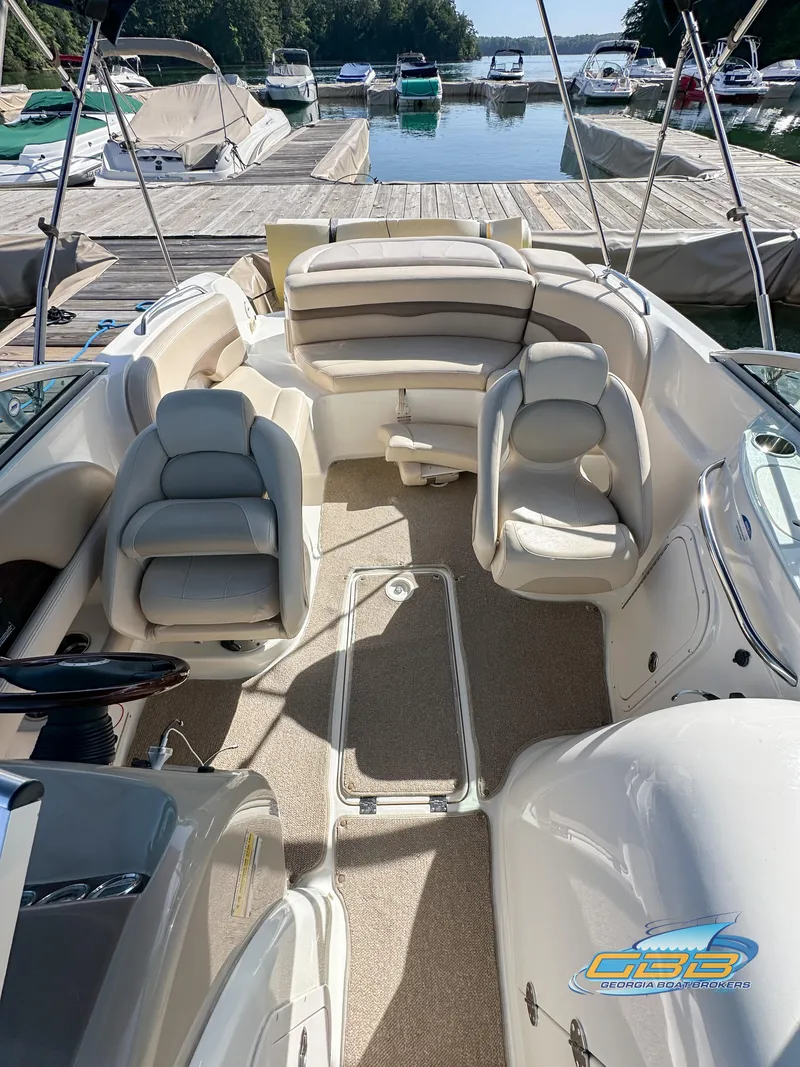 Slide: The Image of 2006 Chaparral Sunesta 236 boat interior with seating, docked at a marina. - 15