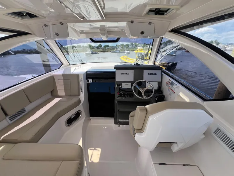 Slide: The Image of 2017 Pursuit OS 355 Offshore boat interior with helm, seating, and navigation equipment. - 14