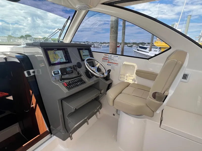 Slide: The Image of 2017 Pursuit OS 355 Offshore boat helm with navigation screens and captain's chair. - 18