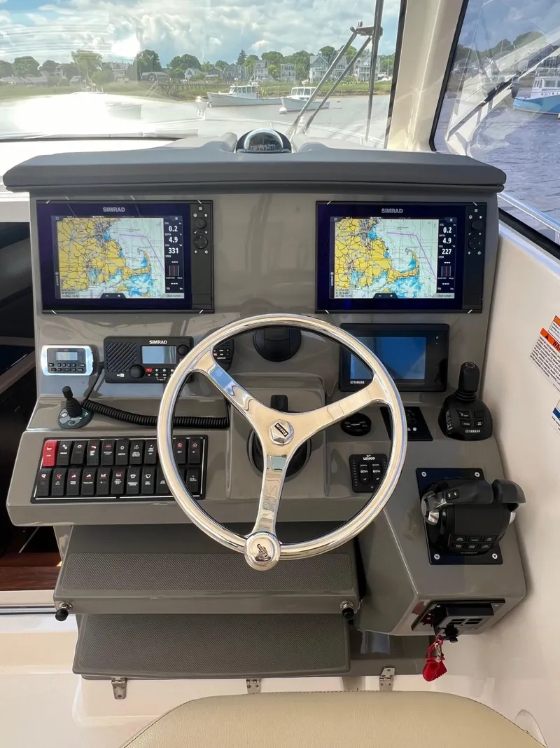 Slide: The Image of Helm station of a 2017 Pursuit OS 355 Offshore boat with dual navigation screens. - 19