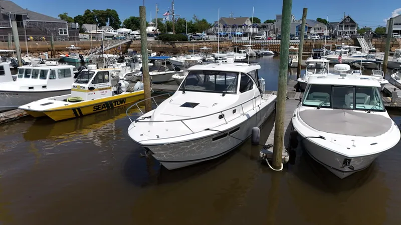 Slide: The Image of 2017 Pursuit OS 355 Offshore boat docked in a marina with other vessels. - 2