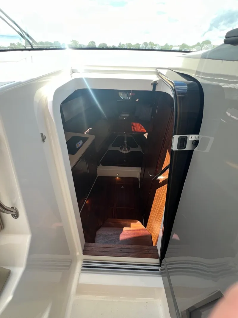 Slide: The Image of 2017 Pursuit OS 355 Offshore cabin entrance with wooden interior. - 22