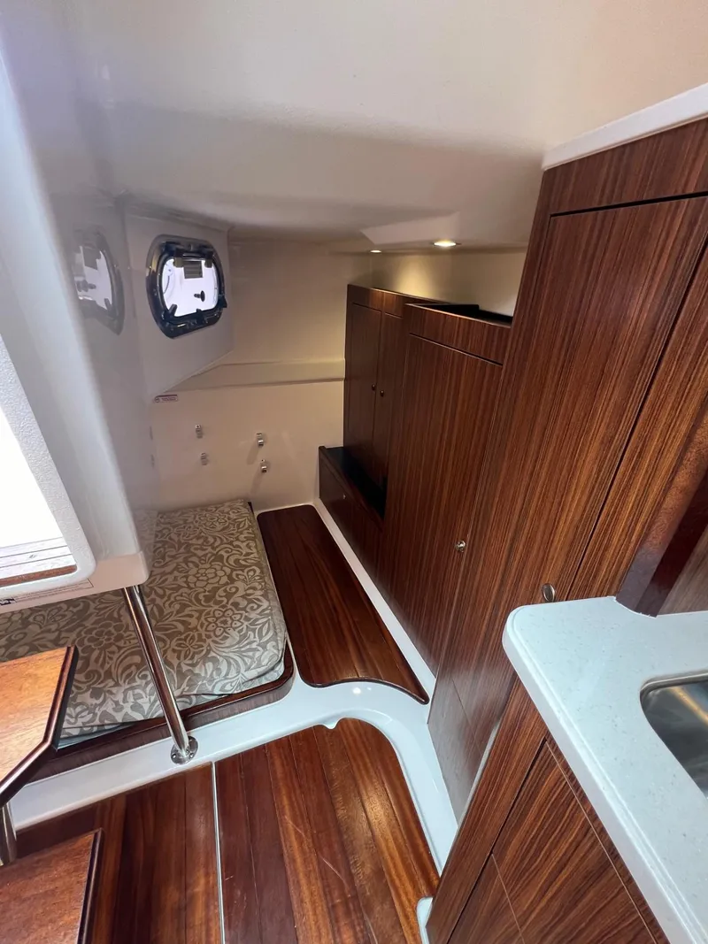 Slide: The Image of 2017 Pursuit OS 355 Offshore cabin interior with wood finish and bed. - 27