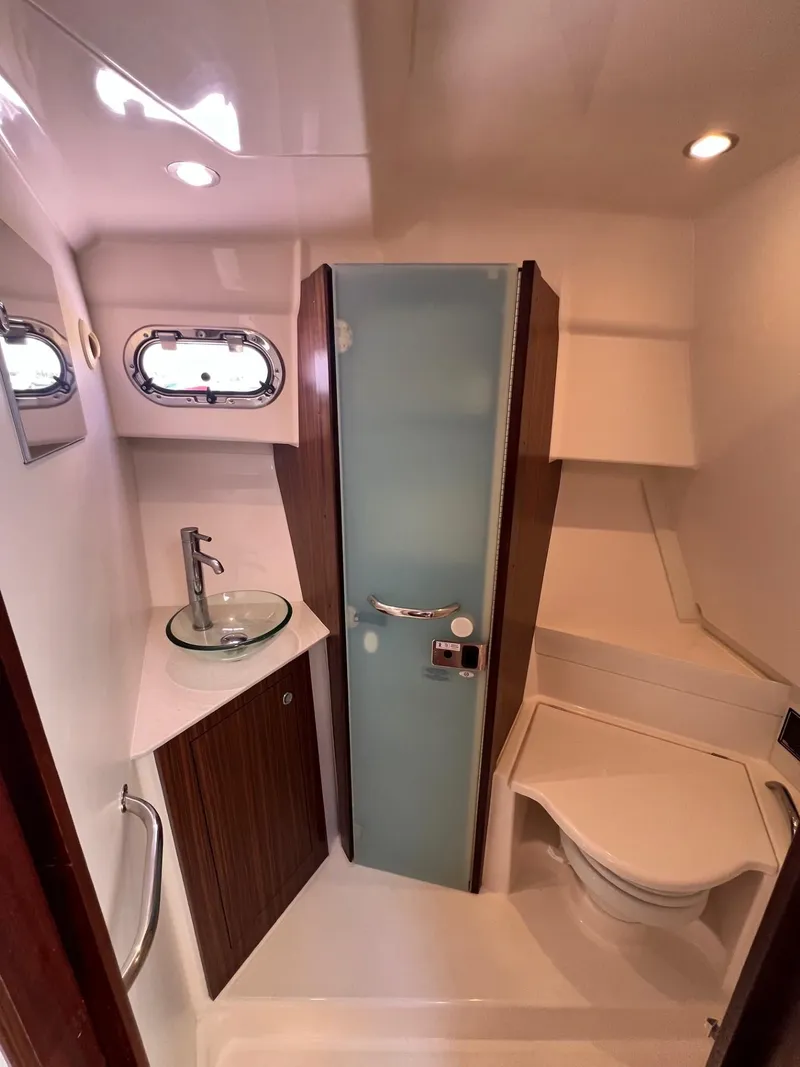 Slide: The Image of 2017 Pursuit OS 355 Offshore boat bathroom with modern fixtures and compact design. - 29