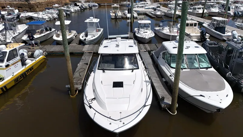 Slide: The Image of 2017 Pursuit OS 355 Offshore boat docked at a marina with other vessels. - 3