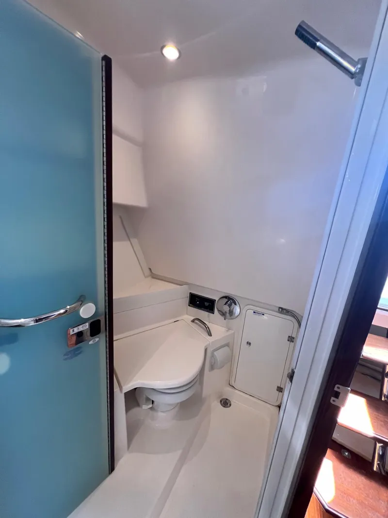 Slide: The Image of 2017 Pursuit OS 355 Offshore bathroom with modern fixtures and blue door. - 30