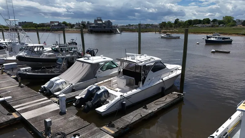Slide: The Image of 2017 Pursuit OS 355 Offshore boat docked at a marina with other boats. - 6