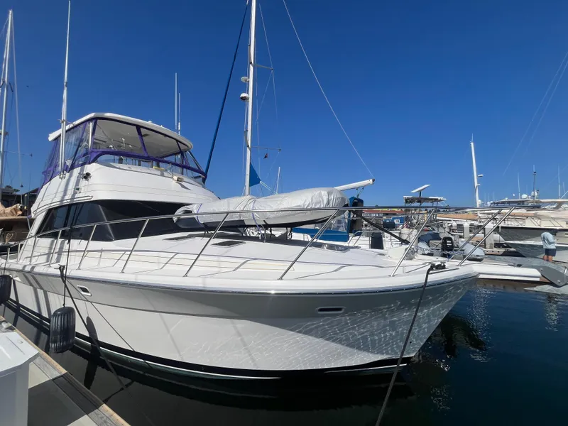 Slide: The Image of 1997 Riviera 43 Open Flybridge docked, sleek design under clear blue sky. - 11