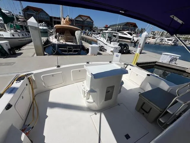 Slide: The Image of 1997 Riviera 43 Open Flybridge yacht docked at marina, spacious deck view. - 12
