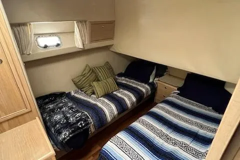 Slide: The Image of 1997 Riviera 43 Open Flybridge cabin with twin beds and striped bedding. - 18