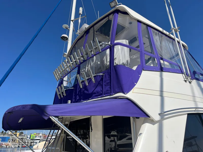 Slide: The Image of 1997 Riviera 43 Open Flybridge with blue canopy in harbor. - 5