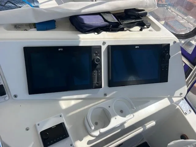 Slide: The Image of Control panel of a 1997 Riviera 43 Open Flybridge with dual screens and cup holders. - 8