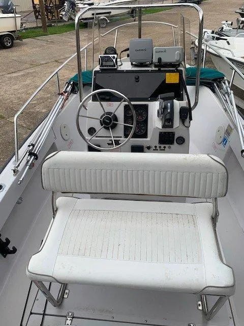 Slide: The Image of 1996 Boston Whaler 17 Outrage II boat interior with steering wheel and seating. - 2