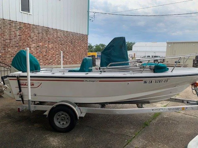 Slide: The Image of 1996 Boston Whaler 17 Outrage II on trailer, parked near brick building. - 4