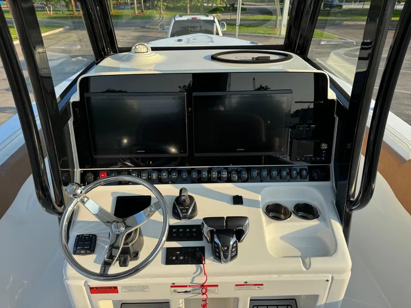 Slide: The Image of 2024 Sea Hunt Gamefish 30 Forward Seating boat console with dual screens and steering wheel. - 11