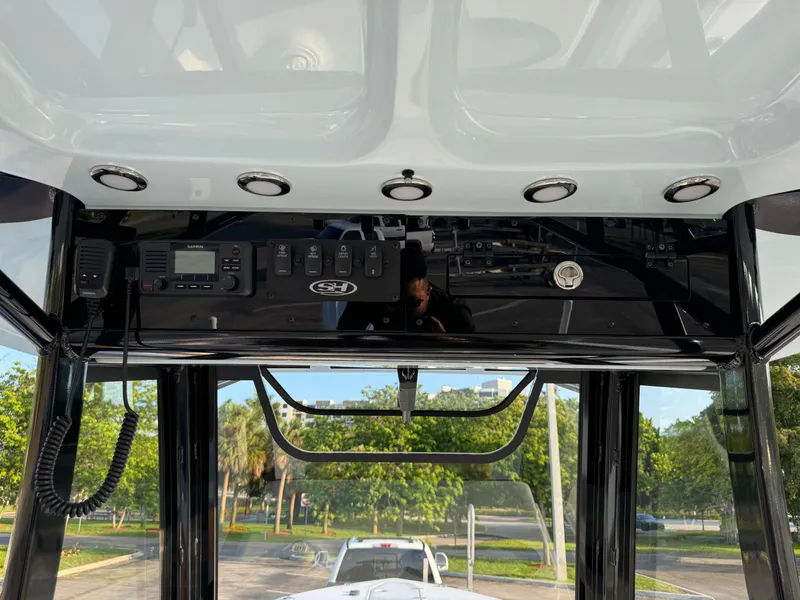 Slide: The Image of 2024 Sea Hunt Gamefish 30 Forward Seating console with electronic controls and overhead lighting. - 12