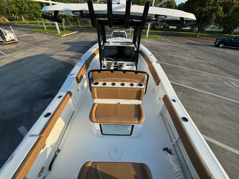 Slide: The Image of 2024 Sea Hunt Gamefish 30 Forward Seating boat interior with tan cushions and center console. - 8