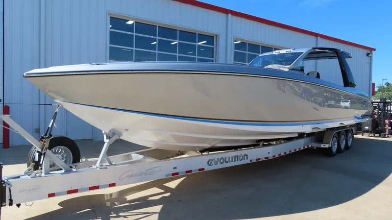 Slide: The Image of 2024 Cigarette 41 Nighthawk SD Edition boat on a trailer outside a garage. - 1
