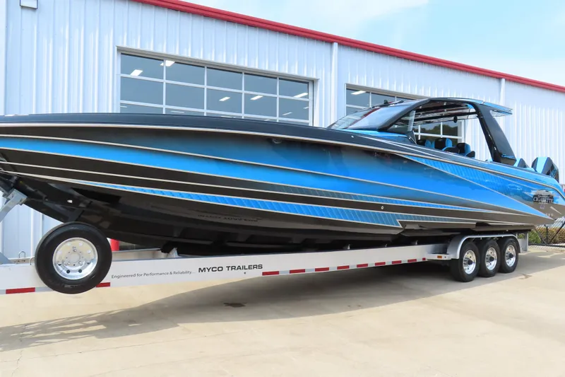 Slide: The Image of 2025 Cigarette 41 Nighthawk boat in blue on a trailer outside a building. - 1