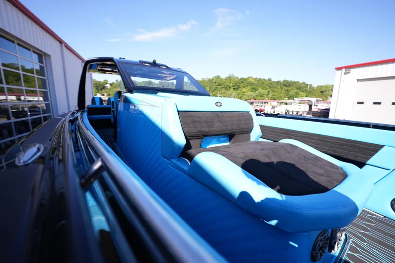 Slide: The Image of 2025 Cigarette 41 Nighthawk boat with blue and black interior at a marina. - 24