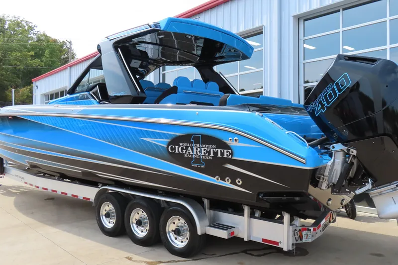 Slide: The Image of 2025 Cigarette 41 Nighthawk boat in blue, parked on a trailer outside a building. - 46