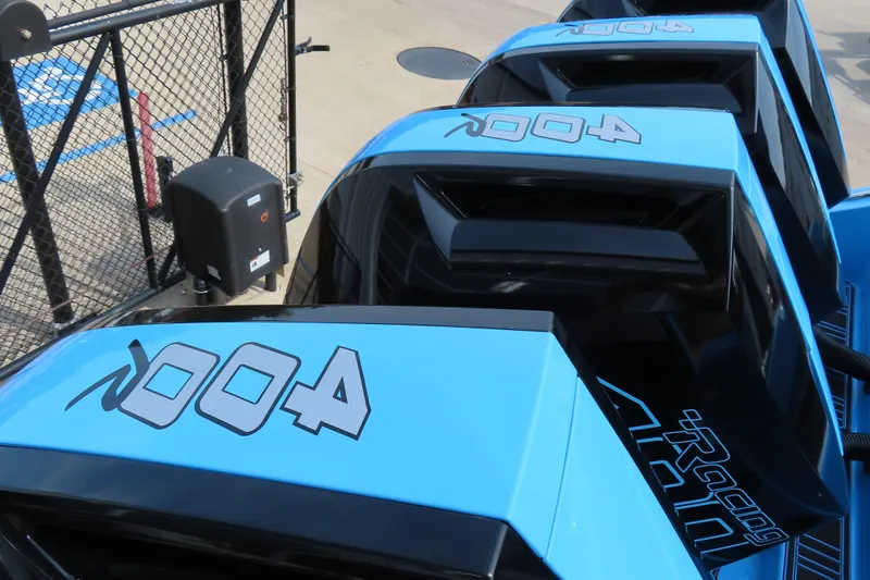 Slide: The Image of 2025 Cigarette 41 Nighthawk boats with blue and black design, docked near a fence. - 64