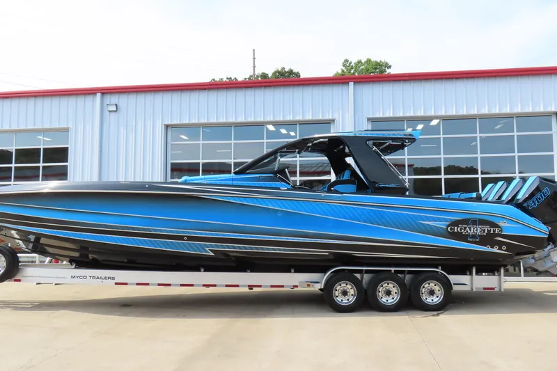 Slide: The Image of 2025 Cigarette 41 Nighthawk boat in blue, parked on a trailer outside a building. - 66