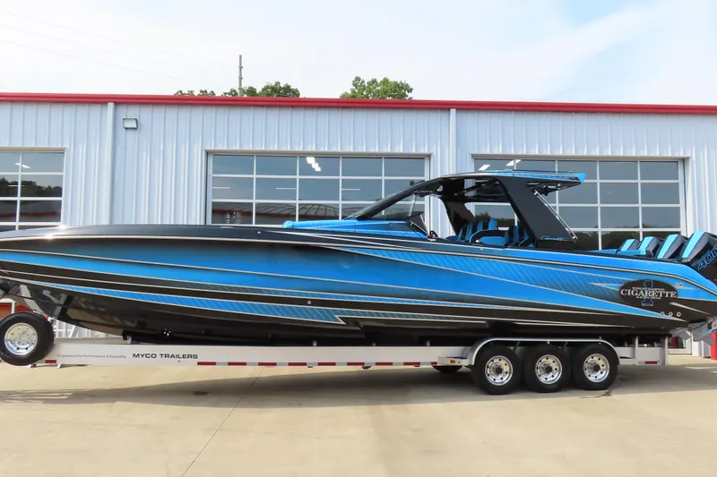 Slide: The Image of 2025 Cigarette 41 Nighthawk powerboat in blue on trailer, parked outside a garage. - 67