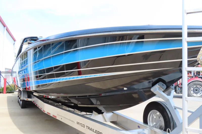 Slide: The Image of 2025 Cigarette 41 Nighthawk boat on trailer, featuring sleek blue and black design. - 68