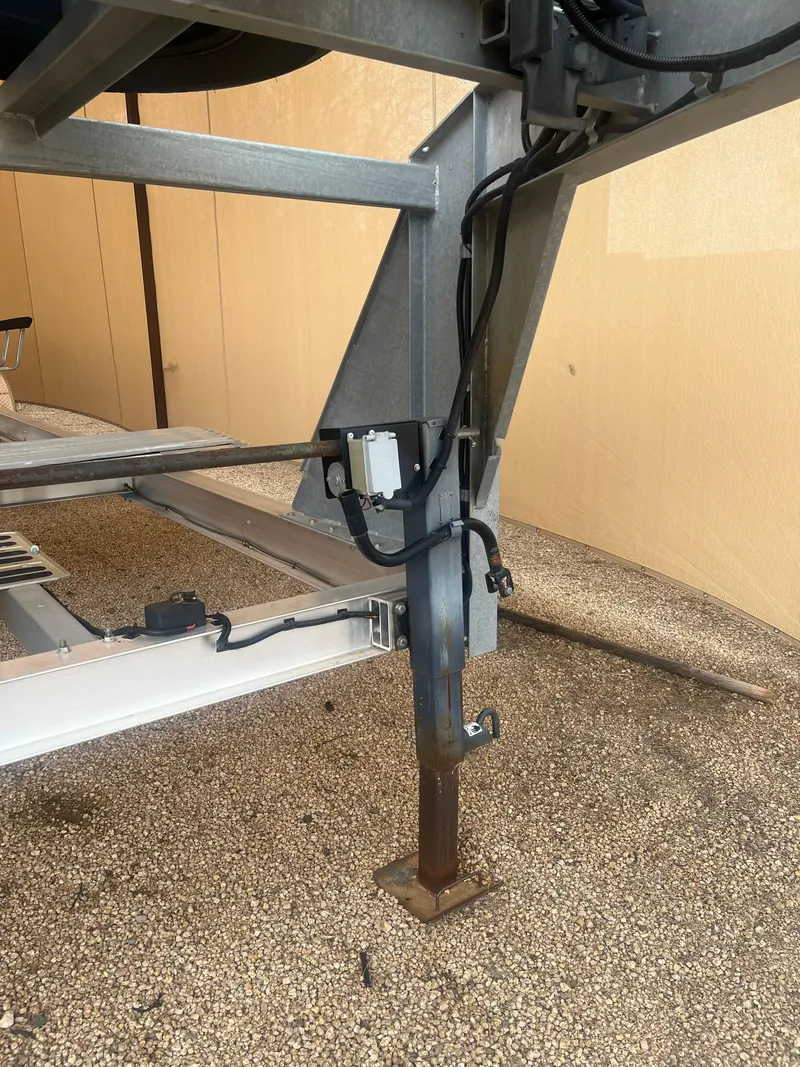 Slide: The Image of 2020 Kokopelli Trailer support leg and wiring on gravel surface. - 4