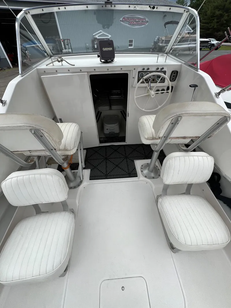 Slide: The Image of 1969 Bertram Bahia Mar 20 boat interior with white seating and steering console. - 6