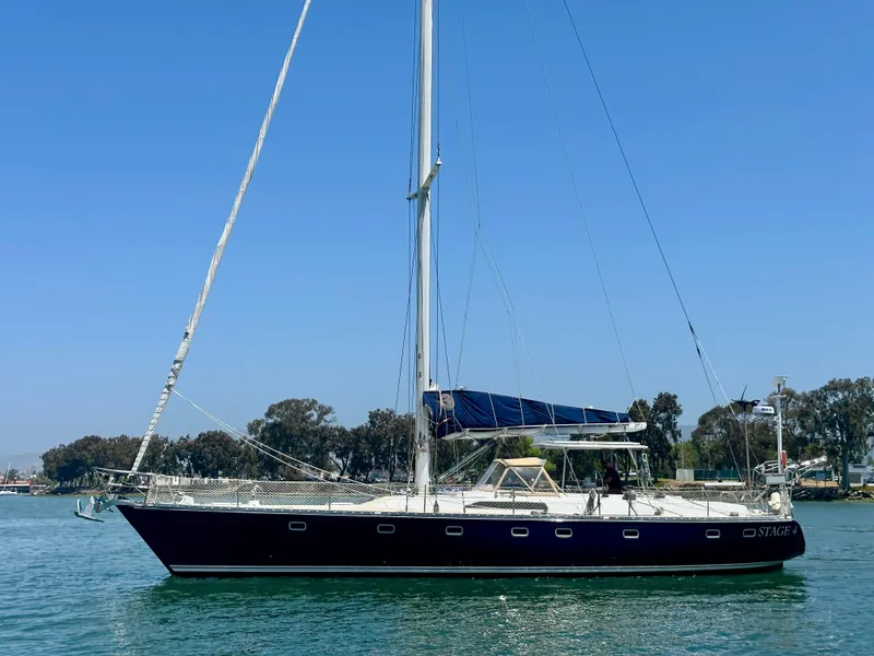 The Image of 1983 Tayana 55 sailboat on calm water, clear sky, side view. - 0