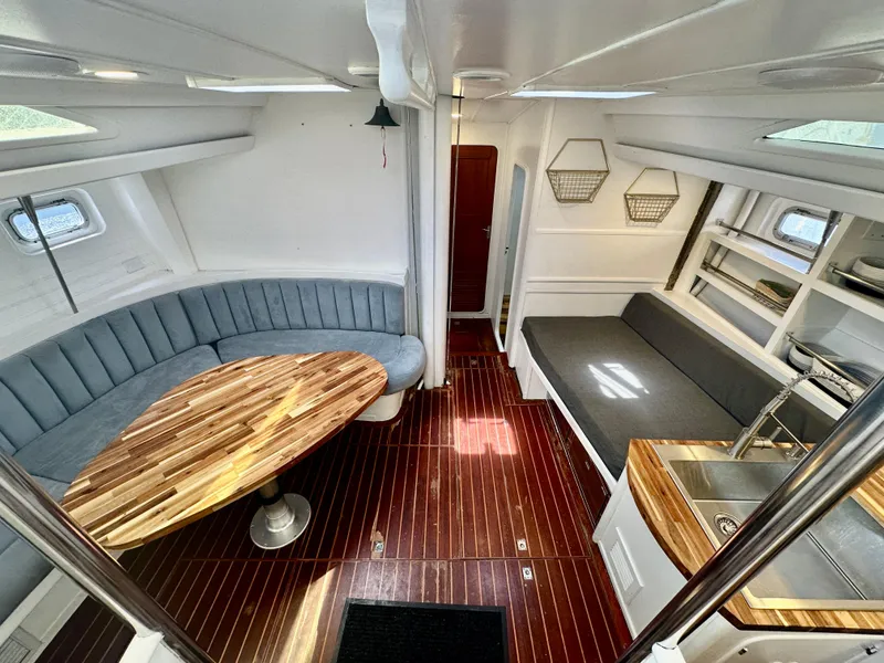 Slide: The Image of Interior of 1983 Tayana 55 yacht with elegant wood flooring and modern seating. - 15