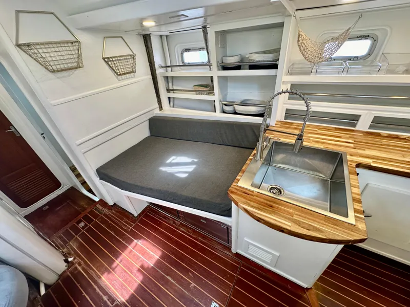 Slide: The Image of Cozy interior of 1983 Tayana 55 yacht with wooden countertops and seating area. - 17