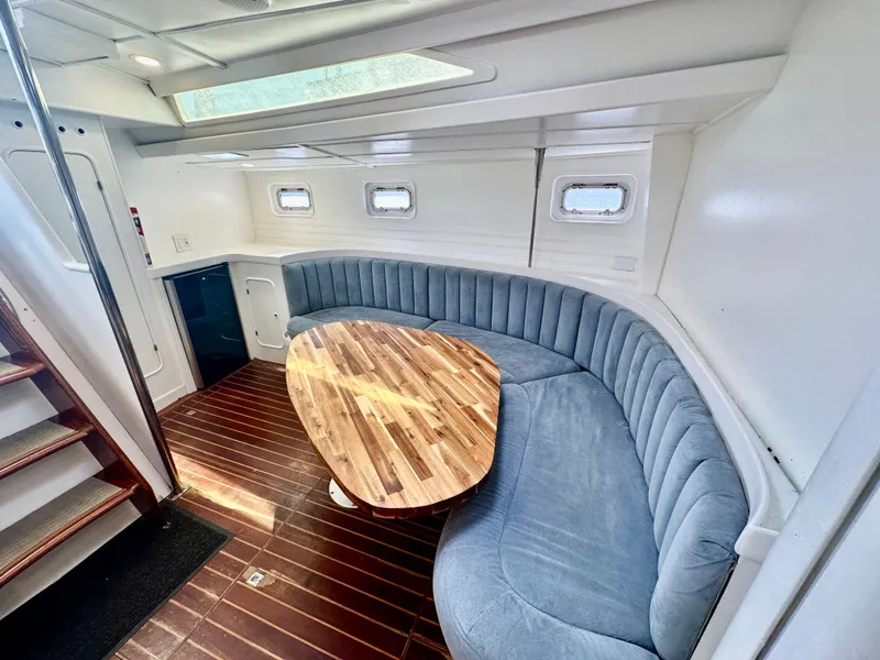 Slide: The Image of Luxurious 1983 Tayana 55 yacht interior with curved seating and wooden table. - 18