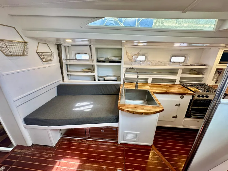 Slide: The Image of Interior of 1983 Tayana 55 yacht with modern kitchen and seating area. - 19