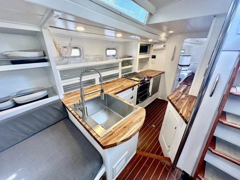 Slide: The Image of Interior of 1983 Tayana 55 yacht with modern kitchen and wooden countertops. - 20