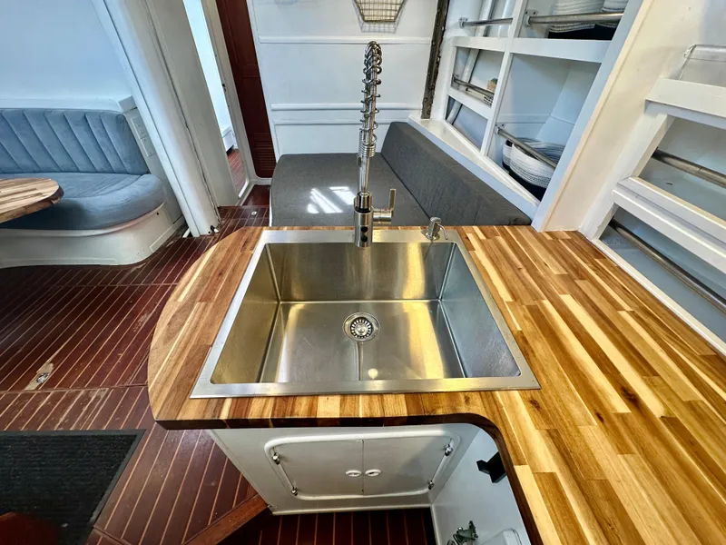 Slide: The Image of Modern kitchen interior on 1983 Tayana 55 yacht with stainless steel sink and wooden countertops. - 21