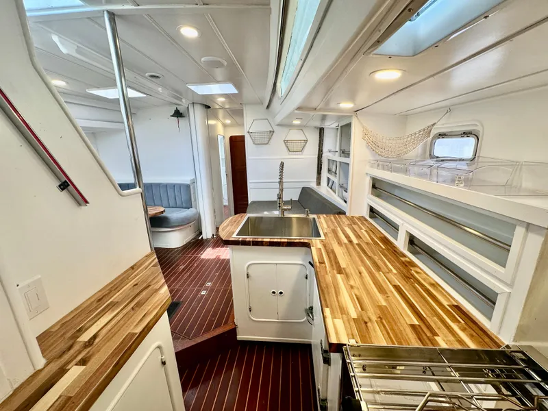 Slide: The Image of Interior of 1983 Tayana 55 yacht with modern kitchen and wooden countertops. - 22