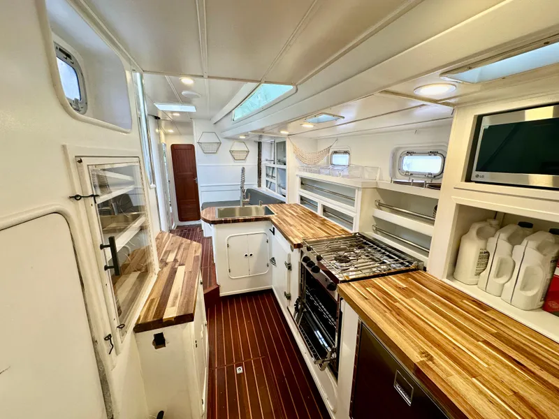 Slide: The Image of Spacious 1983 Tayana 55 yacht interior with modern kitchen and wooden countertops. - 23