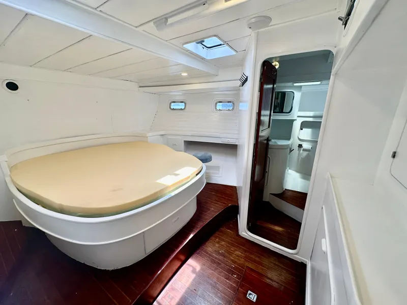 Slide: The Image of 1983 Tayana 55 yacht interior with bed, wooden flooring, and white walls. - 30